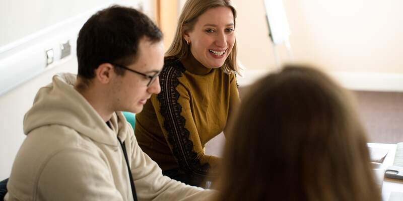 Three students in discussion. Picture taken over third students shoulder